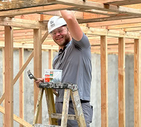 Volunteers Working On House Siding