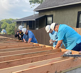 Women Carrying Lumber Volunteer Worksite